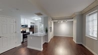 Located at 115 W Monument Ave in Dayton, Ohio, this two-floor residence blends modern updates with functional design across a well-organized layout. The main level centers on an open-concept living and kitchen area, where rich dark hardwood flooring runs throughout and connects the spaces seamlessly. The kitchen is appointed with white shaker cabinetry, granite countertops, a subway tile backsplash, and a full suite of stainless steel appliances, including a smooth-top range, over-the-range microwave, and refrigerator. A peninsula with additional granite countertop space adds convenience and serves as a natural transition into the living area, which features notable ornate crown molding details and track lighting overhead. A staircase leads to the upper level, where the bedrooms offer plush carpeting, neutral gray walls, and ample natural light through blinded windows. The primary bedroom includes access to an en-suite bath featuring white cabinetry, granite countertops, and a well-lit vanity mirror. A second full bathroom on this level mirrors the same clean aesthetic with a tub-shower combination. Throughout the home, a consistent color palette of soft grays and crisp white trim creates a cohesive, move-in-ready atmosphere.