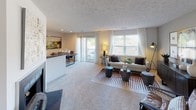 Located in North Royalton, Ohio, this single-floor residence offers a well-designed layout that balances comfort and functionality throughout its key living areas. The living room is a welcoming centerpiece, featuring plush carpeting, a textured ceiling, and a fireplace that anchors the space. Large windows and a sliding glass door flood the room with natural light while providing access to an outdoor area, creating an open and airy atmosphere. A half-wall divider subtly separates the living space from a dining area, adding definition without sacrificing openness. The galley-style kitchen is efficiently arranged with white cabinetry, dark countertops, a stainless steel sink, and black appliances including a refrigerator, electric range, and built-in microwave. Hardwood-style flooring runs through the kitchen, adding warmth and easy maintenance. The bedroom is generously sized with soft carpeting, a large window that invites natural light, and a textured ceiling. The full bathroom features a tub-shower combination, a white vanity with sink, and wood-style flooring for a clean, cohesive look. Completing the unit, a dedicated laundry area is equipped with a full-size washer and dryer alongside wall-mounted wire storage baskets, offering practical organization in a compact space.