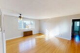 Located at 273 S Winebiddle St in Pittsburgh's Bloomfield neighborhood, this 2-bedroom, 1-bathroom home offers a well-organized single-floor layout. The combined living and dining area is a welcoming centerpiece, featuring warm hardwood flooring, a ceiling fan with light fixture, a classic cast-iron radiator, and a large window that fills the space with natural light and neighborhood views. A pass-through connects this area to the kitchen, enhancing the open feel. The kitchen is equipped with warm wood cabinetry, granite-look countertops, a stylish mosaic tile backsplash, and tile flooring, providing both function and character. Both bedrooms offer carpeted floors, natural light from windows, and access to closet storage — the primary bedroom includes two closets with rich wood-toned doors. The bathroom features a clean, white tub-shower combination with a brushed nickel fixture and a window for natural ventilation. A dedicated entrance and hallway provide smooth flow throughout the home. The layout is efficient and practical, making thoughtful use of every square foot across its compact but complete footprint.