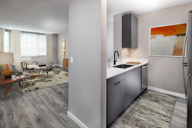 Renovated Package II kitchen, living, and dining areas with hard surface plank flooring - Avalon Midtown West