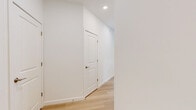 Located at 2220 North Susquehanna Trail in York, PA, this thoughtfully designed single-floor residence offers 2 bedrooms and 2 bathrooms within a bright, open layout. Light-toned hardwood flooring flows throughout the main living areas, complemented by crisp white walls and recessed lighting that create a clean, contemporary aesthetic.

The kitchen and living room share an open-concept footprint, making it ideal for entertaining. The kitchen features white shaker cabinetry extending to the ceiling, quartz countertops, a large center island with an undermount sink, subway tile backsplash, stainless steel appliances, and pendant lighting. The spacious living area benefits from an abundance of natural light, with large sliding glass doors topped by transom windows that open to a private balcony overlooking a scenic outdoor view.

Both bedrooms are carpeted and include ceiling fans and window blinds. The primary bedroom is generously sized and includes a dedicated closet with wire shelving systems for organized storage. The en-suite primary bathroom features light hardwood-style flooring, white cabinetry, a quartz vanity, and a glass-enclosed walk-in shower. The second bathroom mirrors the clean design with a full tub-shower combination, white vanity, and matching flooring. A hallway and additional closet complete this well-appointed home.
