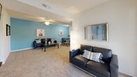 This single-floor residence offers a thoughtfully laid-out floor plan with multiple bedrooms, bathrooms, a living area, kitchen, and in-unit laundry. The open living and dining area sets a welcoming tone, featuring a soft blue accent wall, plush carpeting, ceiling fans, and a textured ceiling. The space flows comfortably from a sitting area to a dining nook, making it well-suited for both relaxing and entertaining.

Each bedroom is distinctly styled with bold accent walls that add personality and visual interest. One bedroom features a vibrant red accent wall paired with a built-in desk setup and sporty décor, while another showcases a warm orange accent wall with a window that invites natural light. A third bedroom is finished in a calming light blue, accented with nautical-themed wall art and soft drapery. All bedrooms are carpeted and include ceiling fans.

The bathrooms are finished with light tile flooring, single vanities with under-sink cabinetry, wall mirrors, and shower-tub combinations with curtains. The kitchen is equipped with white cabinetry, tile flooring, and a full suite of appliances including a refrigerator, electric range, dishwasher, and microwave. A dedicated laundry room houses a full-size washer and dryer with wire shelving above for added storage.