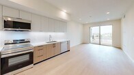 Located at 856 Gramercy Dr in Los Angeles, this well-appointed 2-bedroom, 2-bathroom residence offers a thoughtfully designed single-floor layout with a clean, modern aesthetic throughout. Light hardwood flooring flows seamlessly across the living spaces, complementing the bright, neutral color palette and recessed lighting overhead.

The open-concept kitchen is a standout feature, outfitted with two-tone cabinetry — warm wood lower cabinets paired with sleek light gray uppers — white quartz countertops, a textured tile backsplash, and a full suite of stainless steel appliances including a refrigerator, range, microwave, and dishwasher. The kitchen opens directly into the living area, which is bathed in natural light and connects to a private balcony through sliding glass doors, offering views of the surrounding Los Angeles neighborhood.

The generously sized primary bedroom includes access to a private balcony and benefits from abundant natural light through large windows with city views. Both bedrooms are served by spacious walk-in closets with wrap-around shelving and hanging rods. Each of the two full bathrooms features a tiled tub-shower combination, modern fixtures, and light hardwood-style flooring. Three hallways provide logical flow throughout the unit, connecting all spaces efficiently.