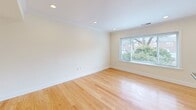 Located at 20 Thornton Road in Brookline, MA, this two-floor residence offers a thoughtfully designed layout spanning two levels. The main floor houses the kitchen and living area, while the upper floor contains the private bedroom suite. Throughout the space, warm-toned hardwood floors and crown molding create a cohesive, polished aesthetic.

The kitchen is well-equipped with stainless steel appliances, including a gas range, microwave, and refrigerator, complemented by warm wood cabinetry and dark granite countertops. A kitchen island with matching granite provides additional prep and seating space. The adjacent living area benefits from multiple windows and a door providing outdoor access, allowing ample natural light and views of the surrounding neighborhood.

The spacious primary bedroom on the upper floor features windows overlooking the exterior, along with access to a dedicated closet with built-in shelving. Two full bathrooms serve the residence: one on each floor. The upper bathroom features white cabinetry with marble countertops and tile flooring, while the lower bathroom offers wood cabinetry with dark granite countertops and tile flooring. Both bathrooms include natural light from windows.
