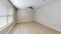 Located at 2107 Pretty Lake Ave in Norfolk, Virginia, this single-floor, two-bedroom unit offers a thoughtfully designed layout that maximizes its well-proportioned footprint. The combined kitchen and living area serves as the heart of the home, with the living room featuring light wood-style luxury vinyl plank flooring and a ceiling fan overhead. Natural light enters through a window fitted with blinds, creating a bright, welcoming atmosphere.

The kitchen is a standout feature, showcasing granite countertops, gray shaker-style cabinetry with gold-tone hardware, and stainless steel appliances including a gas range, microwave, refrigerator, and dishwasher. A window above the counter provides additional natural light. Notably, the kitchen also houses an in-unit washer and dryer concealed behind sliding closet doors—a practical and convenient amenity.

Both bedrooms are carpeted and include ceiling fans and windows that bring in natural light. The primary bedroom is generously sized, offering a sliding-door closet and direct access to an en-suite bathroom. The second bedroom is comparably comfortable. A hallway connects the bedrooms to the main living areas, contributing to an efficient and cohesive floor plan throughout.