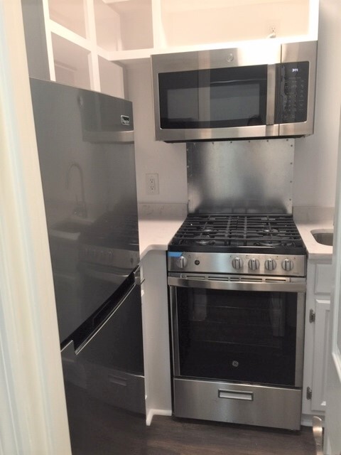 The kitchen has a stainless steel refrigerator, a gas stove/oven, and microwave. - 3819 Gallatin Pike