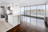Located at 20 N Shore Blvd W in Burlington, Ontario, this well-appointed 4-bedroom, 2-bathroom residence offers a thoughtfully designed single-level layout. The open-concept kitchen is a standout feature, showcasing crisp white shaker cabinetry extending to the ceiling, quartz countertops, a central island with pendant lighting, stainless steel appliances including a French door refrigerator and dishwasher, and a classic subway tile backsplash. The kitchen flows seamlessly into the combined living area, which is distinguished by classic parquet hardwood flooring and floor-to-ceiling sliding glass doors that lead to a private balcony with open outdoor views and an abundance of natural light. The four bedrooms are comfortably sized, with the primary bedroom offering generous proportions and access to a dedicated closet with built-in shelving. Both bathrooms are finished in a clean, contemporary style — one features a sleek glass-enclosed shower with light tile flooring, while the other includes a wide quartz vanity with an undermount sink and a large mirror. Neutral tones and clean white walls throughout create a bright, cohesive ambiance, making this a well-structured and functional residence in a desirable Burlington location.