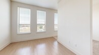Located at 1012 Burnett St in downtown Fort Worth, TX, this efficiently designed unit offers a smart, open-concept layout that maximizes every square foot. The living area is bright and airy, featuring light wood-style flooring and a bank of large windows fitted with blinds that invite generous natural light and offer views of the surrounding cityscape.

The galley-style kitchen is well-appointed with white shaker cabinetry, marble-look stone countertops, a white subway tile backsplash, and a full suite of stainless steel appliances including a refrigerator, electric range, built-in microwave, and dishwasher. The clean, modern aesthetic carries throughout the space with a consistent white-and-neutral palette.

The bathroom is thoughtfully finished with light tile flooring, a wide vanity topped with granite-look counters, white cabinetry with matte black hardware, floating shelves, and a backlit mirror. A dedicated closet adjoins the bathroom, providing organized storage with built-in hanging rods. The overall ambiance of the unit is clean, contemporary, and move-in ready, making it a functional urban residence in the heart of Fort Worth.