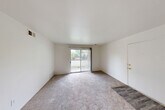 Located at 898 E Grand River Rd in Brighton, Michigan, this 2-bedroom, 1-bathroom residence offers a practical and well-organized single-floor layout. The bright living room features neutral carpet flooring and a sliding glass door that opens directly onto a private balcony, allowing natural light to fill the space while providing pleasant outdoor views of the surrounding greenery.

The galley-style kitchen is efficiently designed with light wood cabinetry, gray countertops, hardwood-style flooring, a gas range, a refrigerator, and a single-basin sink. It flows into a combined dining area that includes a ceiling fan and additional cabinet storage, creating a functional everyday living space.

Both bedrooms are carpeted and finished with neutral white walls. The primary bedroom includes a built-in closet with bi-fold doors and a window dressed with vertical blinds. The second bedroom also benefits from natural light through its own window. A hallway connects the main areas of the unit, and four closets distributed throughout provide ample storage. The bathroom features a tiled tub-and-shower surround in a clean, all-white finish. Throughout the unit, the consistent use of light tones and neutral finishes creates a cohesive, understated aesthetic.