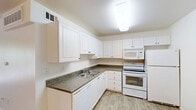 Located at 3946 Via Rosa in San Marcos, California, this single-story, one-bedroom, one-bathroom unit offers a practical and well-organized layout ideal for comfortable everyday living. The open living area features neutral carpeting and transitions seamlessly into the kitchen, which is finished with wood-look flooring. The kitchen is equipped with white cabinetry, dark countertops, a double sink, a full-size electric range, a built-in microwave, a dishwasher, and a refrigerator — providing ample functionality and storage. A wall-mounted HVAC unit ensures climate control throughout the space. The bedroom is a comfortable size, featuring plush carpeting, a large window with vertical blinds that allows generous natural light and views of surrounding greenery, and a mirrored sliding-door closet that enhances the sense of space. The bathroom is clean and straightforward, featuring a tub-shower combination with tile surround, a toilet, and a vanity with dark countertop and integrated sink. The unit's light, neutral color palette throughout creates a bright and cohesive atmosphere. Conveniently situated in the desirable San Marcos area of Southern California, this unit offers a low-maintenance and efficient living environment.