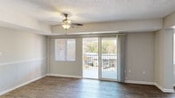 Located at 880 Glendale Dr in Cary, NC, this single-floor residence offers a well-designed layout that balances comfort and functionality. The open living area is finished with durable wood-look flooring and features a ceiling fan, a charming wainscoting-accented half-wall divider, and a front entry door. Natural light pours in through a large sliding glass door that opens to a private balcony, offering pleasant views of the surrounding neighborhood and mature trees. The kitchen is bright and efficient, featuring white cabinetry with ample storage, light granite-style countertops, wood-look tile flooring, and a full suite of white appliances including a range, built-in microwave, refrigerator, and sink. The bedrooms are carpeted for comfort and include ceiling fans and generous closet space, with at least one room featuring a walk-in closet. Additional rooms offer wood-look flooring and neutral wall tones, providing versatility for various uses. The bathroom is clean and functional, with a tub/shower combination and matching wood-look flooring. Throughout the space, a consistent neutral color palette, white trim, and textured ceilings create a cohesive and inviting atmosphere.