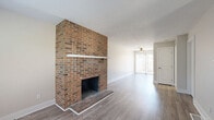 Located in Dublin, OH, this 2-bedroom, 2-bathroom multi-story home is spread across three floors, offering well-defined living spaces throughout. The main living area is anchored by a dramatic full-height brick fireplace that serves as a striking focal point, complemented by wood-look luxury vinyl plank flooring and a ceiling fan overhead. Sliding glass doors lead to a private patio, allowing natural light to fill the room. The kitchen features white shaker-style cabinetry, granite-look countertops, stainless steel appliances, and a double sink, providing a clean and functional layout. A secondary living area on another floor mirrors the brick chimney detail and is finished with plush carpeting. Both bedrooms are carpeted and bathed in natural light, with the spacious primary bedroom offering generous closet access. The home includes five closets in total, providing ample storage throughout. Two full bathrooms are appointed with vanities and tub-shower combinations. The lower level includes basement space suitable for storage or utility use. Neutral tones, textured ceilings, and consistent finishes create a cohesive, move-in-ready atmosphere across all three floors.