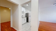 Located in the vibrant Los Feliz neighborhood of Los Angeles, this 2-bedroom, 1-bathroom unit offers a thoughtful blend of classic character and modern updates. Warm hardwood floors flow throughout the living areas and both bedrooms, lending a timeless, inviting feel to the space. The primary bedroom is a comfortable retreat, featuring a ceiling fan and a window that frames views of surrounding greenery. The second bedroom stands out with a striking exposed brick accent wall, dual windows fitted with blinds that allow for ample natural light, and a ceiling fan — giving it a distinctive, loft-inspired character. A hallway connects the rooms and leads to the renovated kitchen, which features white shaker cabinetry with matte black hardware, light tile flooring, white quartz countertops, a stainless steel sink with a black gooseneck faucet, a stainless steel refrigerator, a gas range, and a built-in microwave. The full bathroom is finished in crisp white, with large square wall tiles surrounding the soaking tub and shower, a tiled floor, a white vanity, and clean chrome fixtures throughout. The overall aesthetic is bright, clean, and functional — a well-maintained urban home in one of LA's most sought-after neighborhoods.
