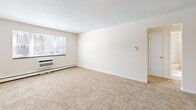 Located at 209 Pleasant Street in Melrose, MA, this two-bedroom, two-bathroom residence offers a practical and well-organized single-floor layout. The combined living and dining area is generously proportioned, featuring wall-to-wall carpeting, baseboard heating, a wall-mounted A/C unit, and a large window that allows natural light to fill the space. The kitchen is thoughtfully designed with white cabinetry accented by warm wood trim, a gas range, dishwasher, stainless steel sink, and durable hardwood flooring — providing a clean and functional cooking environment. Both bedrooms are carpeted and bright, each featuring windows with outdoor views and access to closet storage. The primary bedroom is notably spacious and includes a double louvered closet, offering ample storage. With four closets total throughout the unit, storage is plentiful. The bathroom features classic tilework with a basket-weave tile floor, tile wainscoting, a soaking tub with shower, and a vanity with a lighted mirror above. A hallway connects the rooms, contributing to a smooth and logical flow throughout. Baseboard heating is present throughout the unit, ensuring consistent comfort year-round.