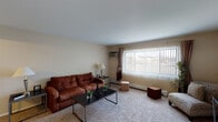 Located at 607 Gundersen Dr in Carol Stream, Illinois, this single-floor residence offers a practical and comfortable layout across several well-defined living spaces. The living room is generously sized, featuring wall-to-wall carpeting and a large picture window dressed with vertical blinds that allows natural light to fill the room while offering views of the surrounding neighborhood. A wall-mounted air conditioning unit and baseboard heating ensure year-round comfort. The kitchen is efficiently designed with light wood cabinetry, a double-basin sink, a white appliance suite including a gas range and dishwasher, and wood-look flooring that extends throughout the functional areas of the home. Under-cabinet lighting adds warmth to the workspace. The bedroom is a tranquil retreat, complete with plush carpeting, a ceiling fan with integrated lighting, and a window with vertical blinds that provides both natural light and privacy. The full bathroom is clean and well-appointed, featuring wood-look flooring, a vanity with under-sink cabinetry, a lighted mirror, and a shower-tub combination with a curtain. Together, these spaces create a cohesive and functional home in a residential Carol Stream setting.