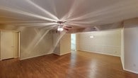 Located at 615 E. Wonsley in Austin, Texas, this single-story home offers a well-organized and functional layout across a comfortable footprint. The interior is anchored by rich hardwood-style flooring that flows throughout the main living areas, creating a warm and cohesive aesthetic.

The spacious main living area is a standout feature, showcasing a ceiling fan with light fixture, neutral-toned walls, and an open sightline that connects seamlessly to adjacent spaces. A charming decorative wall panel with molding detail adds a refined architectural touch to one side of the room, enhancing the overall character of the space.

The layout, as seen from the floor plan, includes a well-proportioned living area, a kitchen with visible appliances and cabinetry, a bathroom with standard fixtures, and additional rooms that provide flexible use. The kitchen is positioned toward one end of the home, offering practical connectivity to the main living space.

Natural light filters into the interior, complementing the light-colored walls and contributing to an airy, inviting ambiance throughout. The single-floor design ensures easy accessibility and a straightforward flow between rooms, making this Austin home a practical and comfortable option.