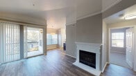 This well-designed single-floor residence offers a thoughtful layout with contemporary finishes throughout. The open-concept living and dining area serves as the heart of the home, featuring elegant crown molding, wood-look flooring, and a striking white-mantled fireplace set against a neutral gray accent wall. Sliding glass doors lead to a private balcony, filling the space with abundant natural light and providing pleasant outdoor views.

The kitchen is a standout feature, showcasing rich dark cabinetry, quartz countertops, a herringbone tile backsplash, and a full suite of stainless steel appliances including a range, microwave, and French door refrigerator. A generous island provides additional prep space and seating, while built-in open shelving nearby adds both function and character.

The primary bathroom is finished with a dual-sink vanity featuring dark cabinetry and quartz countertops, illuminated by stylish brushed nickel lighting. A soaking tub, separate shower, and walk-in closet complete this retreat. An additional bathroom offers similarly refined finishes. The dedicated in-unit laundry room accommodates a full-size washer and dryer with overhead shelving for added storage. Bedrooms are carpeted and filled with natural light, offering a calm and comfortable atmosphere throughout.