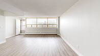 Located at 221 Queen St S in downtown Kitchener, Ontario, this 2-bedroom, 1-bathroom unit offers a thoughtfully designed layout across a single floor. The open-concept kitchen and living area serves as the heart of the unit, featuring light-toned laminate flooring that flows seamlessly throughout. The kitchen is finished with crisp white shaker-style cabinetry, marble-look countertops, a classic subway tile backsplash, stainless steel hardware, and a double undermount sink — creating a clean, contemporary aesthetic. The spacious living area is bathed in natural light through a wide bank of gold-framed windows, complemented by baseboard heating and direct access to a private balcony with urban views. The primary bedroom is a generously sized retreat with a large double bi-fold closet, while the second bedroom includes its own closet and ample floor space. Both rooms continue the light laminate flooring and neutral wall tones. The bathroom is elegantly appointed with a marble-look vanity countertop, an undermount sink, chrome fixtures, and an oval mirror with overhead lighting. A hallway connects all rooms efficiently. The overall ambiance is bright, modern, and move-in ready.