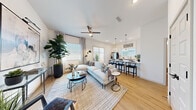 Located at 2120 E Ray Rd in Gilbert, AZ, this single-story, one-bedroom, three-bathroom home offers a well-planned layout that maximizes every square foot of its compact footprint. The open-concept living and kitchen area serves as the heart of the home, featuring warm wood-look flooring, recessed lighting, and a ceiling fan that enhance the bright, airy atmosphere. Large windows invite abundant natural light throughout. The kitchen is outfitted with white and gray shaker-style cabinetry, white quartz countertops, stainless steel appliances, and a breakfast bar with pendant lighting — ideal for both daily living and entertaining. The living area flows seamlessly from the kitchen, offering generous space for relaxing and hosting. The primary bedroom is a serene retreat, filled with natural light from a large window and accented by neutral tones. A dedicated office features multiple windows on two walls, flooding the room with natural light and creating an inspiring work environment. The three bathrooms include a full bath with a tub-shower combo and gray vanity cabinetry, a half bath, and an additional bathroom. A utility room and closet complete the functional layout of this well-appointed Gilbert home.