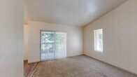 Located in Salem, Oregon, this one-bedroom, one-bathroom residence offers a well-organized single-floor layout designed for practical, comfortable living. The living area features plush carpeting and is filled with natural light through a sliding glass door fitted with vertical blinds, which opens to an outdoor view of lush greenery. A secondary window further brightens the space, creating an open and airy atmosphere.

The galley-style kitchen is efficiently designed with ample white cabinetry, light-toned countertops, wood-look vinyl flooring, and a full suite of white appliances including a refrigerator, electric range, and dishwasher. A ceiling fan with light fixture adds comfort to the kitchen's dining nook, which is lit by a large window overlooking the outdoors. In-unit laundry is conveniently located just off the kitchen entry.

The spacious bedroom accommodates a generous footprint, featuring soft carpeting, multiple windows with blinds for natural light and privacy, and a closet. The clean, neutral palette throughout makes the room versatile and easy to personalize.

The bathroom is finished with wood-look vinyl flooring, a full shower-tub combination, toilet, and a vanity with storage. Clean white walls and simple fixtures give the bathroom a tidy, functional character throughout.