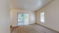 Located in Salem, Oregon, this one-bedroom, one-bathroom residence offers a well-organized single-floor layout designed for practical, comfortable living. The living area features plush carpeting and is filled with natural light through a sliding glass door fitted with vertical blinds, which opens to an outdoor view of lush greenery. A secondary window further brightens the space, creating an open and airy atmosphere.

The galley-style kitchen is efficiently designed with ample white cabinetry, light-toned countertops, wood-look vinyl flooring, and a full suite of white appliances including a refrigerator, electric range, and dishwasher. A ceiling fan with light fixture adds comfort to the kitchen's dining nook, which is lit by a large window overlooking the outdoors. In-unit laundry is conveniently located just off the kitchen entry.

The spacious bedroom accommodates a generous footprint, featuring soft carpeting, multiple windows with blinds for natural light and privacy, and a closet. The clean, neutral palette throughout makes the room versatile and easy to personalize.

The bathroom is finished with wood-look vinyl flooring, a full shower-tub combination, toilet, and a vanity with storage. Clean white walls and simple fixtures give the bathroom a tidy, functional character throughout.