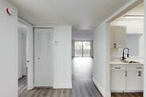 Located at 2725 Somerset Dr in Lauderdale Lakes, Florida, this 1-bedroom, 2-bathroom residence offers a clean, modern aesthetic throughout its thoughtfully laid-out single floor. Durable wood-look plank flooring runs continuously through the space, lending a cohesive and contemporary feel.

The entrance opens into a hallway with convenient closet storage, leading to the expansive combined living and dining area. This open room is bathed in natural light from a large sliding glass door that opens directly onto a private balcony with outdoor views, creating a seamless indoor-outdoor connection. A pass-through window connects the living area to the kitchen, which features white shaker-style cabinetry with dark hardware, light countertops, and stainless steel appliances. A window in the kitchen frames lush tropical greenery outside.

The generously sized primary bedroom is bright and airy, with a large window overlooking the surrounding neighborhood and ample closet space provided by louvered bifold doors. Three closets total are distributed throughout the unit, offering excellent storage.

Both bathrooms are finished in a crisp, contemporary style. One features marble-look tile surrounding a full soaking tub and shower combination, while the second includes a white vanity with clean fixtures and matte black hardware accents. The overall ambiance is light, fresh, and move-in ready.