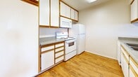 Located at 7622 Katella Ave in Stanton, CA, this one-bedroom, one-bathroom residence offers a thoughtfully arranged single-level floor plan. The combined living and dining area is finished with warm wood-look laminate flooring and features a textured ceiling, neutral walls, and a window with vertical blinds that brings in natural light. A pass-through counter connects the living area to the kitchen, creating an open, functional layout. The kitchen is equipped with white cabinetry featuring wood-trim accents, granite-look countertops, and a full suite of white appliances including an electric range with overhead microwave and a full-size refrigerator. The bedroom offers plush wall-to-wall carpeting, a textured ceiling, a dedicated closet with sliding doors, and a window that allows natural light to filter in. The bathroom is finished with wood-look flooring, a marble-topped vanity with white cabinetry, a large mirror, and a glass-enclosed shower. A private balcony rounds out the layout, providing an outdoor retreat. The unit's clean, neutral palette and consistent finishes create a cohesive and comfortable living environment throughout.