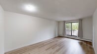 Located at 360 Falshire Dr NE in Calgary, Alberta, this well-appointed 2-bedroom, 1-bathroom unit offers a comfortable and functional single-floor layout. Light-toned hardwood flooring runs throughout the space, creating a clean, cohesive aesthetic that complements the bright white walls and textured ceilings.

The open living room is generously sized, with a sliding glass door that leads to a private balcony overlooking a tree-lined outdoor area. The galley-style kitchen is efficiently designed with white cabinetry extending to the ceiling, ample counter space, and stainless steel appliances including a refrigerator, electric range, and dishwasher.

Both bedrooms are well-proportioned and feature large windows dressed with neutral curtains, allowing for natural light while maintaining privacy. Each bedroom is equipped with a folding-door closet and baseboard heating. The primary bedroom offers a comfortable amount of space for a full furniture arrangement.

The full bathroom includes a single-sink vanity with a large mirror, a toilet, and a tub-shower combination with blue tile surround. A hallway connects all rooms efficiently, completing the practical and tidy floor plan. This unit offers a comfortable living experience in a residential northeast Calgary neighbourhood.
