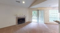 Located at 1300 Longcreek Dr in Columbia, SC, this single-floor residence offers a well-organized layout with a variety of functional living spaces. The living room serves as the focal point of the home, highlighted by a tile-surround fireplace with a classic white mantle and vaulted ceiling detail. A sliding glass door opens to an outdoor balcony, allowing natural light to fill the room and providing views of surrounding greenery. The kitchen features wood-look flooring, light cabinetry, a black refrigerator, a dishwasher, and a range, all arranged in an efficient galley-style configuration. Bedrooms are carpeted and generously sized, with ceiling fans and ample closet space, including walk-in options. Multiple windows fitted with blinds ensure good natural light throughout. The primary bedroom includes direct access to a vanity area with a wide mirror, dedicated lighting, and a walk-in closet, offering added convenience and privacy. The bathrooms are finished with white tile tub-and-shower surrounds and clean, classic fixtures. Textured ceilings are consistent throughout the unit, contributing to a cohesive interior aesthetic. Overall, this residence provides a practical and comfortable living environment in a well-established Columbia neighborhood.