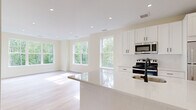 Located at 289 East Rd in Meriden, CT, this well-appointed 2-bedroom, 1-bathroom residence offers a thoughtfully designed single-floor layout. Light hardwood flooring flows throughout the entire space, creating a warm and cohesive aesthetic.

The modern kitchen serves as a central feature, showcasing crisp white shaker cabinetry, white quartz countertops with a subway tile backsplash, and a full suite of stainless steel appliances including a range, microwave, and refrigerator. A peninsula with an undermount sink and matte black faucet provides additional prep space and casual seating.

The spacious living room is bathed in natural light through oversized windows that frame lush, wooded views, with direct access to a private balcony enclosed by sleek dark metal railings — ideal for enjoying the surrounding greenery. The generously sized primary bedroom features multiple large windows offering both wooded and neighborhood views, filling the room with sunlight. The second bedroom is equally well-lit with its own window access.

The full bathroom is finished with white subway tile surrounding a tub/shower combo, brushed nickel fixtures, a white shaker vanity with a stone-top countertop, and matching hardwood flooring. Recessed lighting throughout completes the clean, contemporary feel of this inviting residence.