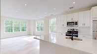 Located at 289 East Rd in Meriden, CT, this well-appointed 2-bedroom, 1-bathroom residence offers a thoughtfully designed single-floor layout. Light hardwood flooring flows throughout the entire space, creating a warm and cohesive aesthetic.

The modern kitchen serves as a central feature, showcasing crisp white shaker cabinetry, white quartz countertops with a subway tile backsplash, and a full suite of stainless steel appliances including a range, microwave, and refrigerator. A peninsula with an undermount sink and matte black faucet provides additional prep space and casual seating.

The spacious living room is bathed in natural light through oversized windows that frame lush, wooded views, with direct access to a private balcony enclosed by sleek dark metal railings — ideal for enjoying the surrounding greenery. The generously sized primary bedroom features multiple large windows offering both wooded and neighborhood views, filling the room with sunlight. The second bedroom is equally well-lit with its own window access.

The full bathroom is finished with white subway tile surrounding a tub/shower combo, brushed nickel fixtures, a white shaker vanity with a stone-top countertop, and matching hardwood flooring. Recessed lighting throughout completes the clean, contemporary feel of this inviting residence.