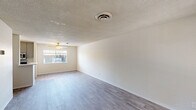 Located at 4140 North 78th Street in Scottsdale, Arizona, this single-floor unit offers a practical and well-designed layout with one bedroom and two full bathrooms. The open living area is characterized by light gray laminate flooring, crisp white walls, and a textured ceiling, creating a clean and bright atmosphere. A ceiling fan and window allow natural light to fill the space, enhancing its airy feel. The galley-style kitchen is efficiently organized with gray cabinetry, white countertops, a stainless steel sink, and stainless steel appliances including a gas range and refrigerator, all illuminated by a modern ceiling light fixture. The spacious primary bedroom features the same laminate flooring, a large window with blinds for natural light, and generous closet storage with sliding doors. Additional built-in storage cabinetry is found along the hallway, offering practical organizational space. The two bathrooms include a full bath with a tiled tub-shower combination and window, as well as a vanity bathroom featuring a modern mirror, gray cabinetry, and white countertops. The consistent flooring and neutral color palette throughout create a cohesive and move-in-ready living environment.