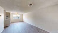 Located at 4140 North 78th Street in Scottsdale, Arizona, this single-floor unit offers a practical and well-designed layout with one bedroom and two full bathrooms. The open living area is characterized by light gray laminate flooring, crisp white walls, and a textured ceiling, creating a clean and bright atmosphere. A ceiling fan and window allow natural light to fill the space, enhancing its airy feel. The galley-style kitchen is efficiently organized with gray cabinetry, white countertops, a stainless steel sink, and stainless steel appliances including a gas range and refrigerator, all illuminated by a modern ceiling light fixture. The spacious primary bedroom features the same laminate flooring, a large window with blinds for natural light, and generous closet storage with sliding doors. Additional built-in storage cabinetry is found along the hallway, offering practical organizational space. The two bathrooms include a full bath with a tiled tub-shower combination and window, as well as a vanity bathroom featuring a modern mirror, gray cabinetry, and white countertops. The consistent flooring and neutral color palette throughout create a cohesive and move-in-ready living environment.