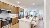 This thoughtfully designed 1-bedroom, 1-bathroom residence in Centennial, Colorado offers a cohesive open-concept layout that maximizes every square foot. The kitchen is a standout feature, showcasing warm wood cabinetry that extends to the ceiling, white quartz countertops, a subway tile backsplash, and a full suite of stainless steel appliances. A generous island with seating serves as both a dining and gathering space, flowing seamlessly into the living room. The living area is bright and airy, with large windows dressed in layered curtains that allow abundant natural light, complemented by light wood-style flooring and a ceiling fan overhead. A dedicated workspace nook with a window view adds functional versatility. The bedroom is comfortably sized, featuring a large window with outdoor views and direct access to the bathroom, which includes a sleek single-sink vanity with wood cabinetry, white quartz countertop, and large-format tile flooring. A closet provides added storage. Clean white walls, recessed lighting, and consistent modern finishes throughout lend this residence a polished, cohesive ambiance well-suited for everyday living.