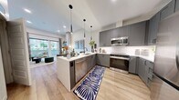 Unit 512 at 855 N. Broadway is a 720-square-foot, one-bedroom, one-bathroom apartment in Denver, CO, designed with modern urban living in mind. The open-concept kitchen and living area serves as the heart of the unit, featuring light wood-style flooring throughout. The kitchen is appointed with gray shaker cabinetry, white quartz countertops, stainless steel appliances, sleek pendant lighting, and a peninsula with bar seating — ideal for both cooking and entertaining. The living room offers generous natural light through large sliding glass doors that open directly onto a private balcony, providing outdoor views of the surrounding Denver neighborhood. The 150-square-foot bedroom continues the light and airy aesthetic with a large window, wood-style flooring, and access to a spacious walk-in closet outfitted with multi-tier shelving and hanging rods. The full bathroom features large-format tile flooring, a gray double vanity with a white countertop, a wide mirror, and a walk-in shower with white tile surround. Clean lines, neutral tones, and consistent finishes throughout give this apartment a cohesive, contemporary feel well-suited to Denver living.