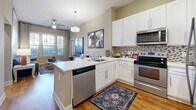 Located in Huntersville, NC, this thoughtfully designed 2-bedroom, 2-bathroom residence delivers a functional and inviting single-floor layout. The kitchen serves as a central hub, featuring crisp white cabinetry, a mosaic tile backsplash, stainless steel appliances including a refrigerator, range, microwave, and dishwasher, and a peninsula with a built-in sink — ideal for both cooking and casual dining. Warm hardwood-style flooring runs throughout the kitchen and bathrooms, tying the space together cohesively.

The primary bedroom is a comfortable retreat, brightened by large windows with blinds and curtains that allow natural light to filter in. A ceiling fan adds practicality, and ample space accommodates generous furnishings. The second bedroom mirrors this warmth with plush carpeting and natural light. Both bedrooms are supported by dedicated closets with wire shelving for organized storage.

Each bathroom is well-appointed with a white vanity, single-sink countertop, full tub-shower combination, and wood-look flooring. The neutral, warm-toned walls throughout the residence create a calm and welcoming ambiance. A connecting hallway links all rooms seamlessly, rounding out a practical and polished floor plan.