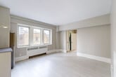 Located at 2166 Boulevard De Maisonneuve Ouest in Montréal, this one-bedroom, one-bathroom unit offers a thoughtfully laid-out single-floor plan finished in a clean, neutral palette. Light-toned wood flooring runs throughout, complementing the soft greige walls and bright white trim that give the space a cohesive, airy feel.

The living area is the largest space in the unit, anchored by a wide bank of windows that frame views of the surrounding Montréal cityscape and flood the room with natural light. A baseboard heating unit beneath the windows provides year-round comfort.

The kitchen is efficiently designed with ample white cabinetry extending to the ceiling, stainless steel appliances including a range, dishwasher, and refrigerator, and a dedicated sink with additional counter space. It connects seamlessly to a hallway entry with its own overhead lighting and direct access to the front door.

The bedroom is a well-proportioned, quiet retreat featuring its own window with city views and a baseboard heater. Its layout comfortably accommodates standard furnishings. The bathroom is finished entirely in crisp white tile, featuring a full soaking tub and a clean vanity, maintaining the unit's consistent minimalist aesthetic throughout.