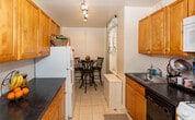 Located at 44 High St in Perth Amboy, New Jersey, this single-floor residence offers a well-organized and functional layout designed for comfortable everyday living. The entryway welcomes visitors with durable wood-look flooring, clean white paneled doors, and charming decorative touches that set a warm tone throughout the home. The kitchen is efficiently designed, featuring warm wood cabinetry, dark countertops, a subway tile backsplash, and standard appliances including a dishwasher and full-size refrigerator. Light tile flooring extends into a cozy dining nook with a window, providing a pleasant spot for meals. The living area is a comfortable gathering space with hardwood-style flooring, natural light from a large curtained window, and room for classic, substantial furnishings. The bedrooms are well-proportioned, each featuring hardwood-style flooring, windows with decorative curtains, and ample space for bedroom furniture and storage. The bathroom is clean and neatly finished with white tile walls, a pedestal sink, a mirrored medicine cabinet, and a shower/tub combination. Throughout the residence, neutral wall tones and consistent flooring materials create a cohesive and inviting atmosphere.