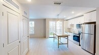 This contemporary 650 square foot apartment offers a thoughtfully designed living space on a single floor. The open-concept layout maximizes the use of space, creating a seamless flow between the living areas. The kitchen is a standout feature, boasting sleek white cabinetry, stainless steel appliances, and a subway tile backsplash. A generous granite-topped island serves as both a prep area and casual dining spot.

The bedroom, measuring 130 square feet, is carpeted for comfort and features a ceiling fan and large window, allowing for ample natural light and air circulation. The bathroom is modern and functional, with a spacious walk-in shower, marble-look tile, and a floating vanity with granite countertop.

Throughout the apartment, light-toned wood-look flooring enhances the bright, airy feel. Large windows in the living areas and bedroom offer views of the surrounding cityscape. The unit also includes a walk-in closet with efficient wire shelving systems for organized storage.

Energy-efficient lighting fixtures and recessed lighting contribute to the modern ambiance. The apartment's neutral color palette provides a versatile backdrop for various decor styles, making it easy for residents to personalize their space.