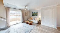 This well-designed two-story home in Statesboro, Georgia offers a thoughtful layout spread across two floors. The main level features an open-concept living, dining, and kitchen area bathed in natural light. The living room is anchored by light wood-tone flooring, crown molding, a ceiling fan, and a large sliding glass door that opens to outdoor views, creating a bright and airy atmosphere. Adjacent to the living area, the dining room is highlighted by an elegant chandelier, large windows with linen drapes, and direct sightlines to the kitchen. The kitchen is equipped with stainless steel appliances, gray shaker-style cabinetry, granite countertops, and a classic subway tile backsplash. A utility room and a half bathroom round out the lower level. The staircase leads to the upper floor, where the spacious primary bedroom features plush carpeting, a ceiling fan, and a closet. A full bathroom serves the upper level. Throughout the home, a neutral color palette and consistent flooring choices create a cohesive and inviting aesthetic. The two-bathroom configuration adds convenience, making this home both functional and comfortable for everyday living.