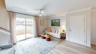 This well-designed two-story home in Statesboro, Georgia offers a thoughtful layout spread across two floors. The main level features an open-concept living, dining, and kitchen area bathed in natural light. The living room is anchored by light wood-tone flooring, crown molding, a ceiling fan, and a large sliding glass door that opens to outdoor views, creating a bright and airy atmosphere. Adjacent to the living area, the dining room is highlighted by an elegant chandelier, large windows with linen drapes, and direct sightlines to the kitchen. The kitchen is equipped with stainless steel appliances, gray shaker-style cabinetry, granite countertops, and a classic subway tile backsplash. A utility room and a half bathroom round out the lower level. The staircase leads to the upper floor, where the spacious primary bedroom features plush carpeting, a ceiling fan, and a closet. A full bathroom serves the upper level. Throughout the home, a neutral color palette and consistent flooring choices create a cohesive and inviting aesthetic. The two-bathroom configuration adds convenience, making this home both functional and comfortable for everyday living.