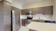 This contemporary 600 square foot apartment in AMLI Dadeland, Miami, offers a harmonious blend of style and functionality. The open-concept layout maximizes the use of space, creating a seamless flow between living areas. The kitchen is a standout feature, boasting sleek wooden cabinetry, stainless steel appliances, and a convenient island with a quartz countertop, perfect for meal preparation or casual dining.

The bedroom, measuring 140 square feet, provides ample space and is bathed in natural light from a large window. Light-toned wood flooring runs throughout, complementing the neutral wall colors and adding warmth to the space. The bathroom features modern fixtures, a tub-shower combination, and elegant tile work.

High ceilings and recessed lighting contribute to the apartment's airy feel. The unit also includes a hallway and closet space for additional storage. Located in the desirable Dadeland area of Miami, this apartment combines urban convenience with contemporary comfort, making it an ideal choice for modern city living.