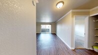 This single-floor unit in Alameda, California offers a clean, functional layout with a welcoming ambiance throughout. The living area features wood-style flooring and crown molding, with natural light streaming in through a sliding glass door that opens to a private balcony with outdoor views. The open flow from the entryway into the living space creates a bright, airy feel.

The kitchen is equipped with stainless steel appliances, including an electric range and an over-the-range microwave, complemented by white cabinetry and sleek gray countertops — providing both style and practicality.

The bedroom features plush wall-to-wall carpeting and includes a dedicated walk-in closet, offering ample storage. A second bedroom or additional room is also carpeted and benefits from a large window that brings in generous natural light, with a baseboard heating system along the wall. The bathroom is fitted with a full tub-shower combination with white tile surround and chrome fixtures.

Throughout the unit, neutral tones, textured ceilings, and consistent finishes create a cohesive and move-in ready environment. The combination of hardwood-style floors in living areas and soft carpet in bedrooms adds both comfort and practicality to this Alameda residence.