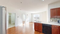 Located at 255 E Grand Ave in Rahway, NJ, this 2-bedroom, 2-bathroom residence offers a thoughtfully designed single-floor layout with a clean, modern aesthetic throughout. Rich hardwood flooring flows seamlessly across the living spaces, complemented by bright white walls and an abundance of natural light streaming through multiple windows.

The open kitchen and dining area is a functional highlight, featuring warm cherry wood cabinetry, light stone countertops, a mosaic tile backsplash, and stainless steel appliances including a range and dishwasher. The adjacent living room is bright and airy, offering a comfortable gathering space.

Both bedrooms are well-proportioned and sun-filled, each featuring large windows with exterior views and wall-unit HVAC systems. The primary bedroom includes access to a generously sized walk-in closet outfitted with wire shelving and organizational racks. Two additional closets provide ample storage throughout the unit.

The two bathrooms are finished with light tile flooring. One features a tiled standing shower, while the other includes a single vanity with cherry wood cabinetry and a large mirror. A versatile den adds flexible living space. The welcoming entrance completes this well-appointed residence.
