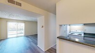 Located at 2211 Sedgwick St in Petersburg, Virginia, this single-floor residence offers two bedrooms and two bathrooms within a well-organized, efficiently laid out floor plan. Durable wood-style flooring flows throughout the living areas and bedrooms, providing a cohesive and clean aesthetic. The living room is a comfortable, open space featuring a textured ceiling and a sliding glass door fitted with vertical blinds, allowing generous natural light and outdoor views. A closet in the living area provides convenient storage. The kitchen is positioned adjacent to the main living space and features granite-style countertops, white cabinetry, a range, and a full-size refrigerator. A pass-through counter connects the kitchen to the hallway, enhancing the open feel of the common areas. Both bedrooms are well-proportioned, with the primary bedroom offering ample space and natural light from a dedicated window. The two bathrooms include a full bath with a tiled tub-shower combination and a second bath with a vanity and medicine cabinet. A central hallway connects all rooms, contributing to a functional and straightforward layout throughout the home.