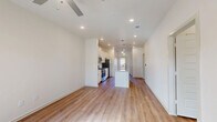 This single-story, 2-bedroom, 2-bathroom home offers a thoughtfully designed open-concept layout that maximizes functionality and flow. The combined kitchen and living area serves as the heart of the home, featuring warm wood-look flooring, recessed lighting, and ceiling fans that enhance comfort throughout. Natural light streams in through multiple windows, brightening the living space considerably.

The kitchen is a standout feature, equipped with white shaker-style cabinetry, a subway tile backsplash, granite countertops, and a center island with a built-in sink and pendant lighting overhead. Stainless steel appliances, including a refrigerator, electric range, and microwave, complete this well-outfitted culinary space.

Both bedrooms are comfortably sized, with the primary bedroom offering a ceiling fan, a window with natural light, and dedicated closet space. The second bedroom similarly features a ceiling fan and natural light. Four closets throughout the home provide generous storage options.

Both bathrooms are finished consistently with white cabinetry, granite-topped vanities, brushed nickel hardware, and tub/shower combinations with clean white tile surrounds. Wood-look flooring carries into the bathrooms, maintaining a cohesive aesthetic. A dedicated laundry area adds everyday convenience to this clean, modern home.