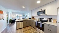 Located at 2050 Durant Ave in Berkeley, CA, this 2-bedroom, 2-bathroom residence offers a well-designed layout across a single floor. The open-concept kitchen and living area form the heart of the home, featuring two-tone cabinetry with white upper and gray lower cabinets, stainless steel appliances including a refrigerator, electric range, over-the-range microwave, and dishwasher, all complemented by light countertops and wood-style flooring throughout. Recessed lighting keeps the space bright and modern. The living area provides a comfortable retreat with room for seating and easy access to adjacent spaces. Both bedrooms are well-proportioned, with the primary bedroom offering generous space, and both rooms benefit from large windows that invite abundant natural light and frame city views of the Berkeley skyline. The two bathrooms are finished consistently with gray vanities, white countertops, full tub-shower combinations, and wood-style flooring. A dedicated in-unit laundry area with a stacked washer and dryer adds everyday convenience. The entryway offers a welcoming transition into the home. Clean lines, neutral tones, and consistent finishes throughout give this residence a cohesive, contemporary feel well-suited to the vibrant Berkeley neighborhood it calls home.