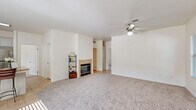 This single-story, 3-bedroom, 2-bathroom home in Bakersfield, CA offers a well-organized and functional layout. The open-concept living, dining, and kitchen area forms the heart of the home, featuring plush carpeting, a ceiling fan, and a tile-surround fireplace that anchors the living space. Natural light flows in through windows with blinds, creating a bright and welcoming atmosphere. The kitchen is well-appointed with white cabinetry, granite countertops, stainless steel appliances including a gas range, microwave, and refrigerator, and tile flooring. A pantry provides additional storage convenience. The primary bedroom is generously sized with a ceiling fan, carpet, and a window overlooking the outdoors. Additional bedrooms are equally comfortable, each with carpet and ceiling fans. The bathrooms feature tile flooring, white vanity cabinetry, and granite countertops. A dedicated laundry room houses a full-size washer and dryer with overhead cabinetry. Multiple closets throughout provide ample storage. The attached garage offers additional utility space. The home's neutral color palette and cohesive finishes create a clean, move-in-ready environment throughout.