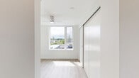 Located at 1145 SW 170th Ave in Beaverton, Oregon, this one-bedroom, one-bathroom apartment offers a clean, modern aesthetic throughout its efficiently designed single-floor layout. Light wood-tone flooring runs continuously through the space, complementing the crisp white walls and creating a bright, cohesive feel.

The kitchen is a standout feature, outfitted with warm wood-grain cabinetry, white subway tile backsplash, white quartz countertops, and a full suite of stainless steel appliances including a refrigerator, dishwasher, range, and over-the-range microwave. Open shelving adds a contemporary touch and enhances the sense of openness.

The bedroom is a well-proportioned private retreat featuring a large window that invites natural light and offers outdoor views of the surrounding neighborhood. A full-width sliding closet provides generous storage while maintaining a streamlined, modern look.

The bathroom is thoughtfully designed with a wood-toned vanity, an illuminated frameless mirror, a white undermount sink, and a full soaking tub with shower. The light flooring carries through here as well, maintaining the unit's consistent, airy aesthetic.

Overall, this apartment presents a contemporary and functional living environment with quality finishes and a clean design sensibility well-suited for comfortable everyday living.