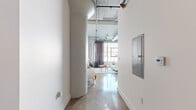 Located in the heart of Downtown Los Angeles on Santee Street, this stylish urban loft showcases a compelling blend of industrial character and contemporary design. The open-plan living area immediately impresses with its soaring ceilings, exposed HVAC ductwork, and gleaming polished concrete and terrazzo floors that reflect abundant natural light pouring in through large, steel-framed factory-style windows. Track lighting throughout adds both functionality and a modern edge.

The kitchen is thoughtfully appointed with light wood cabinetry, stainless steel appliances including a full-size refrigerator and range, and a striking blue mosaic tile backsplash that adds a vibrant focal point. Generous counter space and ample storage make it as practical as it is attractive. A stacked in-unit washer and dryer offer added convenience.

The bedroom provides a serene retreat, accessed through a warm wood-toned sliding door. It features polished floors, high ceilings, track lighting, and a frosted-glass sliding panel that opens to a built-in closet. The bathroom is elegantly finished with a wood-accented vanity, slate-toned flooring, and a full soaking tub enclosed by frameless sliding glass doors and accented with deep blue tile — a spa-like escape within this urban residence.